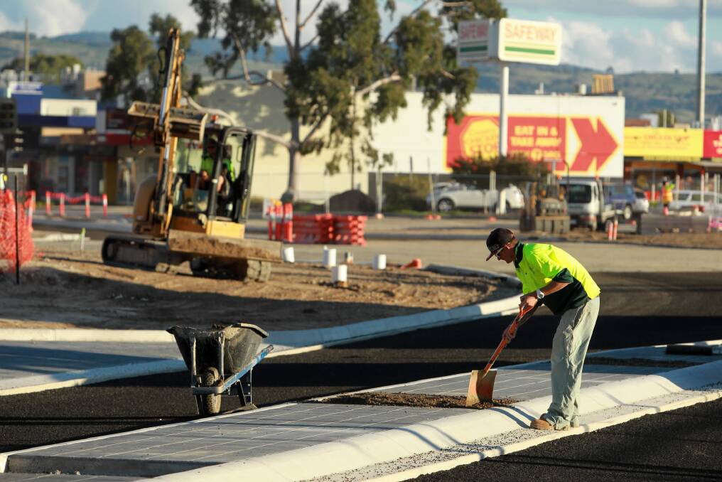 A worker completes a median strip before the re-opening of High Street. Picture: MATTHEW SMITHWICK