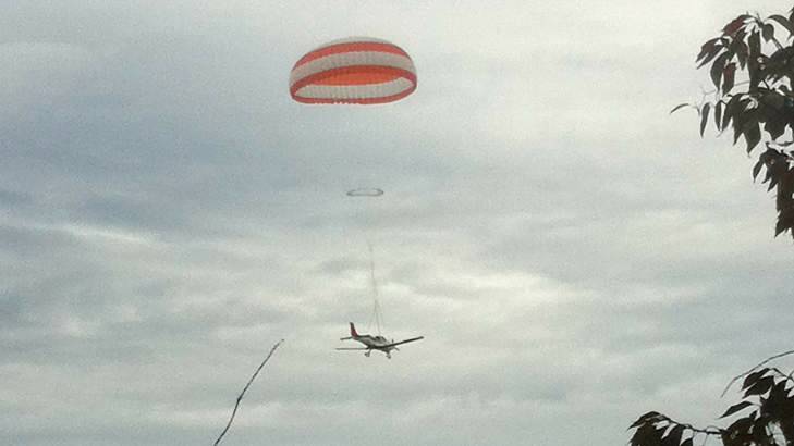 A light plane comes to the ground using a parachute to soften the impact. Photo: Claire Hills