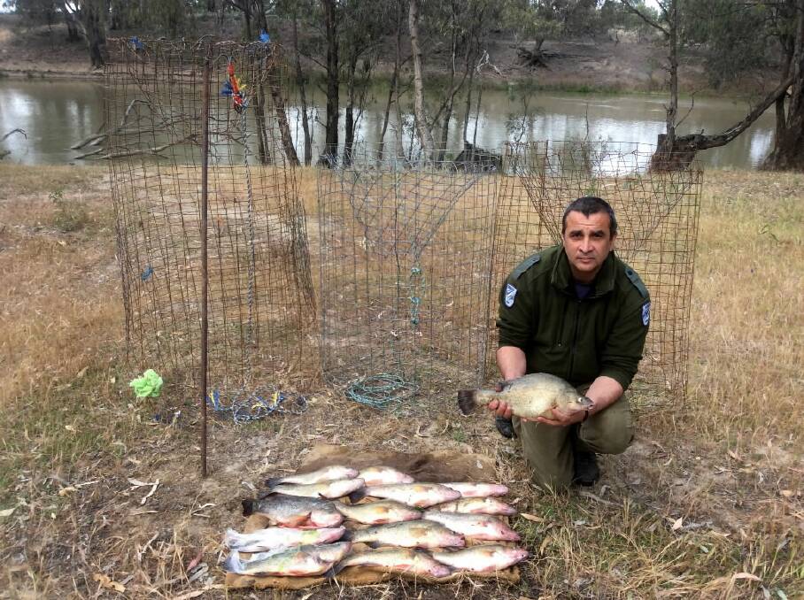 A fisheries officer displays the seized fish and drum nets.