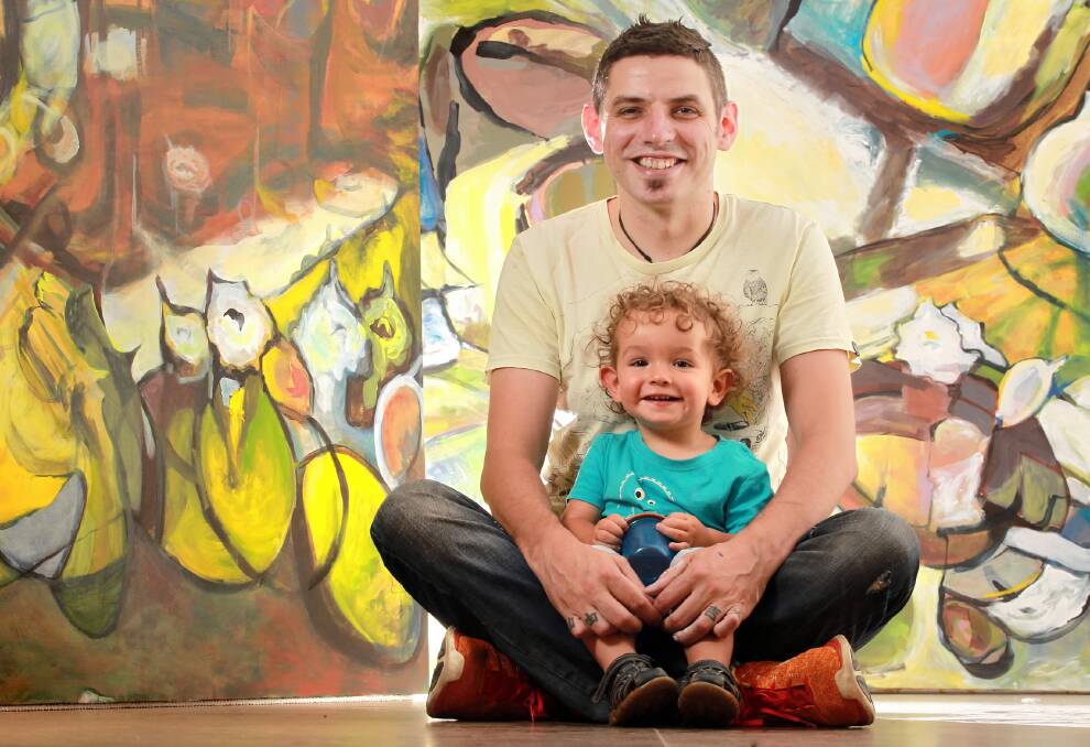 Artist Dan Mahon and his son Archie, 16 months, with two of his exhibition works. Picture: KYLIE ESLER
