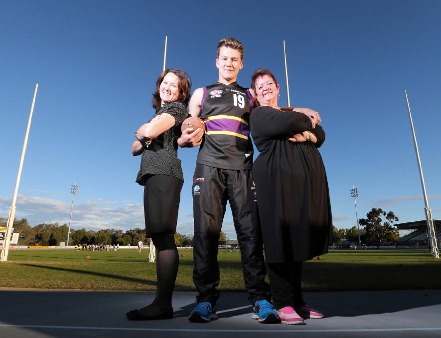Murray Bushrangers Murray Waite, 17, takes time out at Norm Minns Oval to remember his grandfather, WWII veteran Peter Chitty, alongside his mum Erica Waite and his aunt Ros Taylor, ahead of today’s game. Picture: JOHN RUSSELL