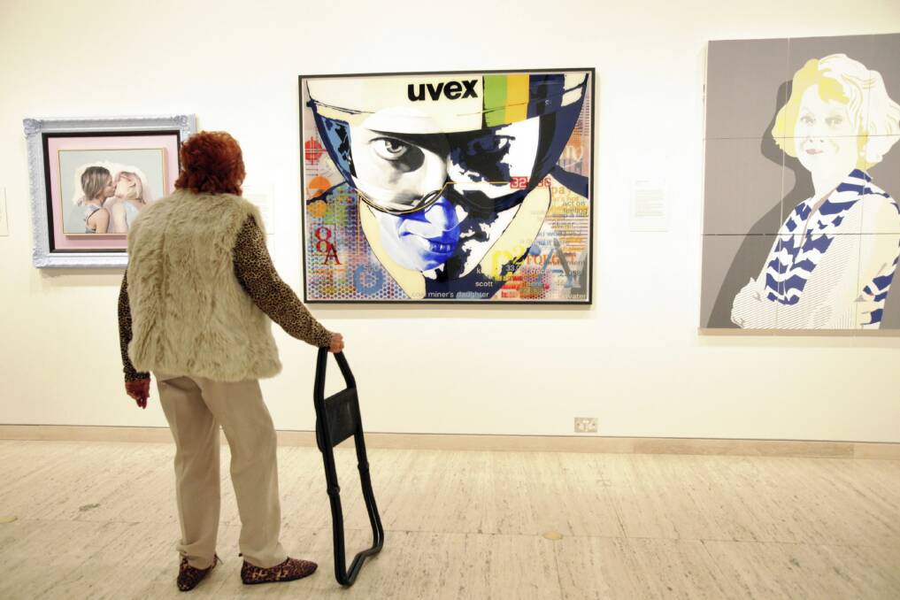 A gallery visitor admires the portrait of Australian cyclist Anna Meares painted by Phillip Barnes.