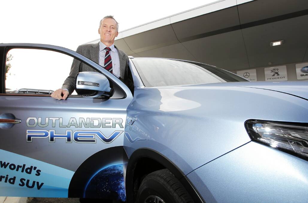 Martin Baker with an electric-hybrid Mitsubishi Outlander PHEV, which has a rated fuel usage of 1.9 litres for every 100 kilometres, The Albury-Wodonga dealer supports proposed cheaper registration costs for safer and greener passenger vehicles. Picture: DAVID THORPE