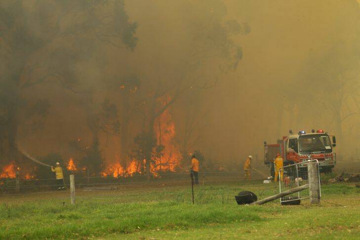 Bushfire threatening homes, property and livestock between Tomago and Williamtown. Picture shows fire fighters at a property along Cabbage Tree Road, Williamtown.