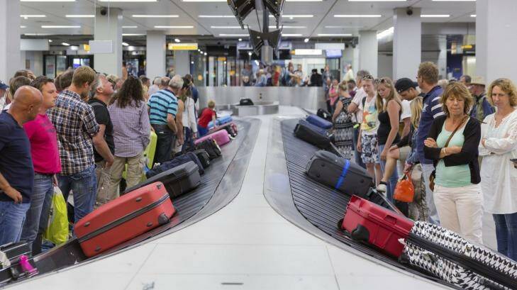 Travelers wait for their luggage from a conveyor belt. Photo: iStock