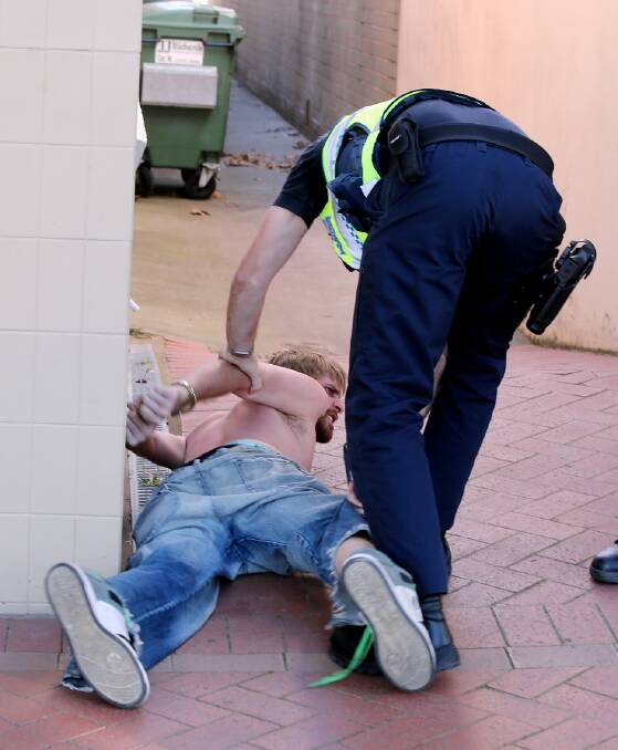 Police tackle a man to the ground after a brawl in High Street, Wodonga. Pictures: PETER MERKESTEYN