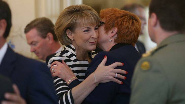 Senator Marise Payne is embraced by Senator Michaelia Cash before the ministry swearing in ceremony at Government House on Monday. Photo: Andrew Meares