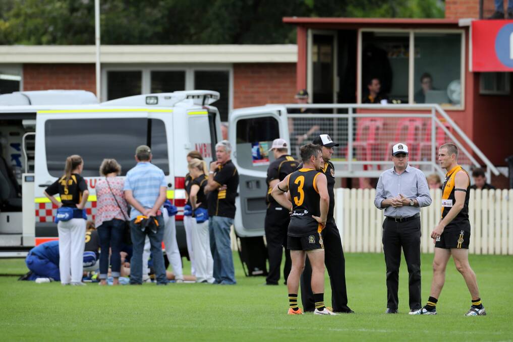 Albury co-coaches Daniel Maher and Chris Hyde discuss their next move with club president Gavan Schultz and Tigers vice-president and player welfare manager Paul Joss as James McQuillan is treated by trainers and ambulance officers.