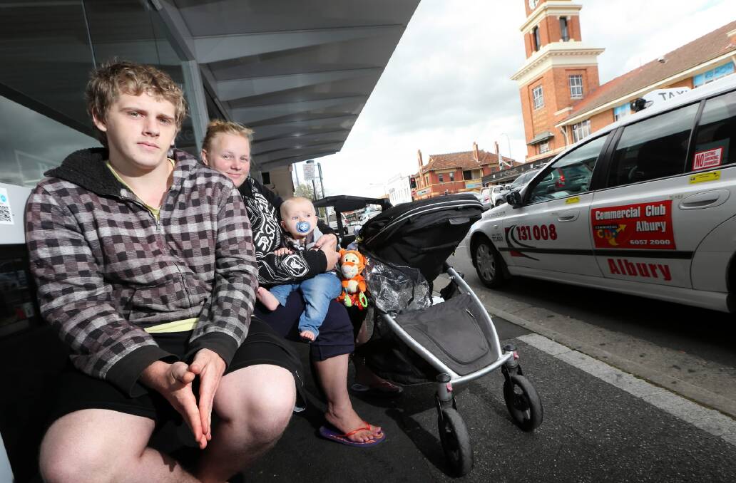 Rhys Wilton, Jade Heeman and Coby Wilton, 7 months, at the Olive Street taxi rank yesterday. The family fears a price rise would mean they would be forced to reassess their taxi use. Picture: JOHN RUSSELL