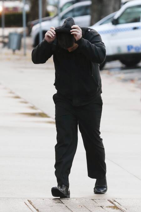 Justin James Wishart covers his head as he arrives at court yesterday.