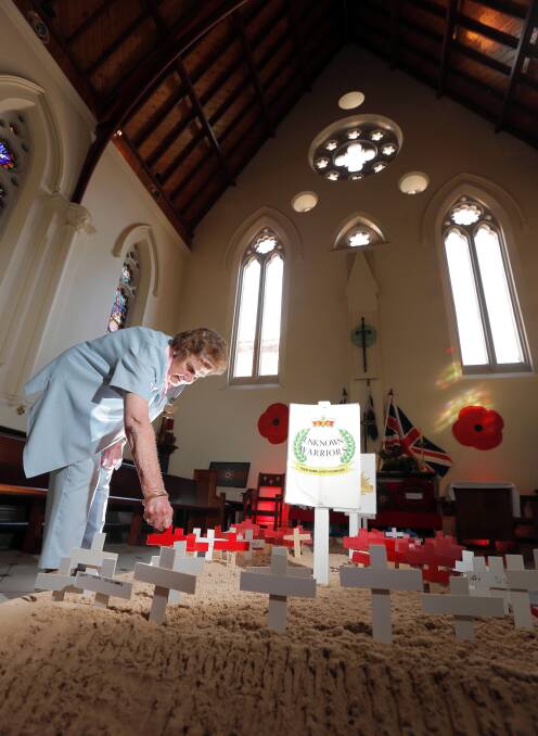 Val Evans lays a cross during the Field of Remembrance ceremony yesterday. Picture: KYLIE ESLER
