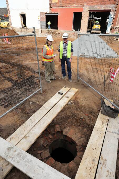 Archaeologist Sarah Myers, of Archlink Archaeologists and Heritage Advisors, and construction manager Steve Escott stand near the opening of a brick-lined tank on the site of the Albury Art Gallery redevelopment. The tank was built in 1868, when the site was a telegraph office. It is about 3.7 metres deep and about 3.6 metres in diameter. Sarah detected the tank, one of two associated with a nearby well, on the original plans of the site, and they were found during excavations. Pictures: MATTHEW SMITHWICK