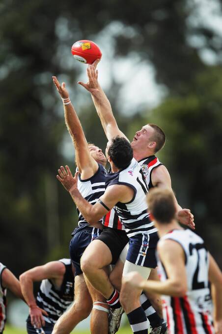 Wodonga Saints’ Hugh Edmondson outreaches Rutherglen’s Dallas Gallagher and Lindsay Seymour in this ruck duel on Saturday. Picture: DYLAN ROBINSON