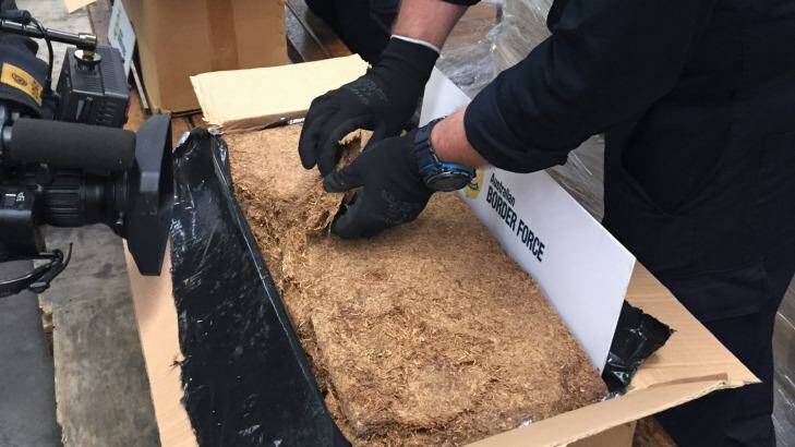Customs officers sort through some of the 71-tonnes of illicit tobacco they seized in June, 2015   Photo: Paul Bibby
