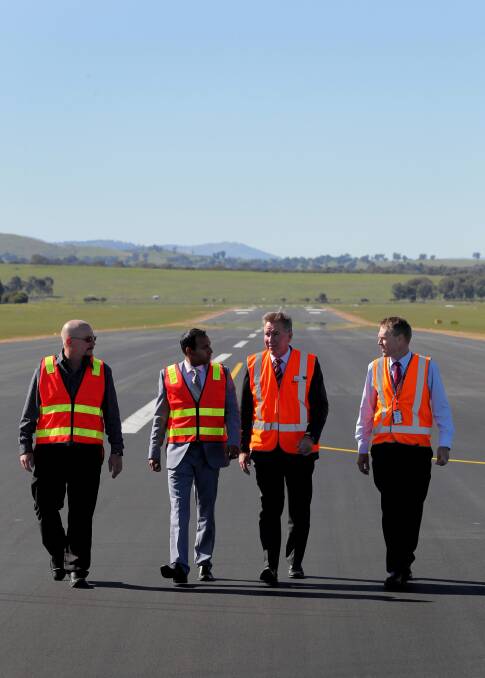 Albury’s re-sealed runway gets an inspection from Downer manager Joel Nicholls, Downer general manager Gana Varendran, Albury Mayor Kevin Mack and airport manager David Costello. Picture: DAVID THORPE