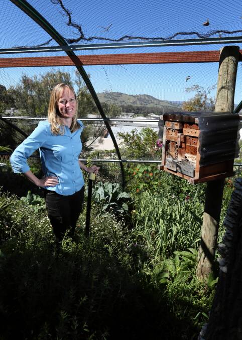 Karen Retra in her garden with a “bee hotel” she made from drilled timber. Picture: MATTHEW SMITHWICK