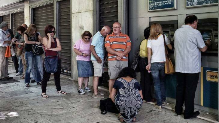 Athenians queue up to withdraw money from an ATM. The Greek government has imposed a €60 daily limit. Photo: Milos Bicanski