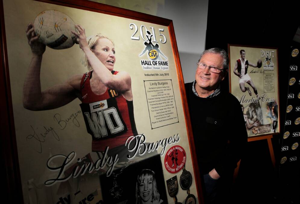 Myrtleford stalwart and Ovens and Murray Hall of Famer Martin Cross reveals the poster welcoming the league’s first female inductee, Lindy Burgess, into the prestigious club of O and M greats. Picture: DAVID THORPE