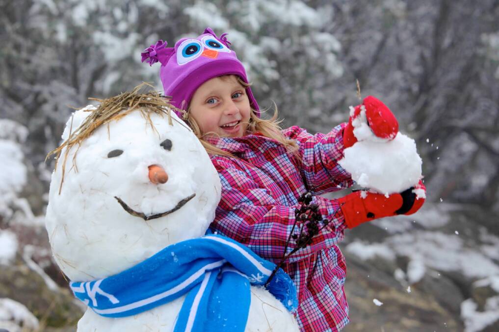 Falls Creek’s Jacinta Jansen, 5, breaks out the snow gear early to build a snowman on the mountain on Saturday. Picture: CHRIS HOCKING