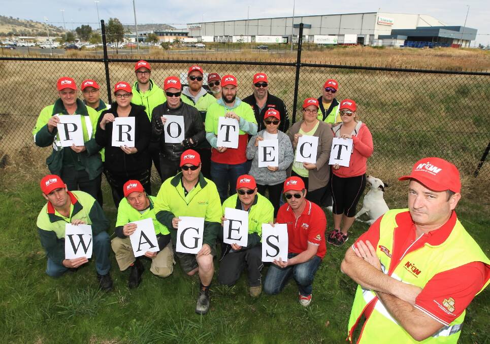 Neil Smith with workers who are determined to “protect wages” at the distribution centre. Picture: DYLAN ROBINSON