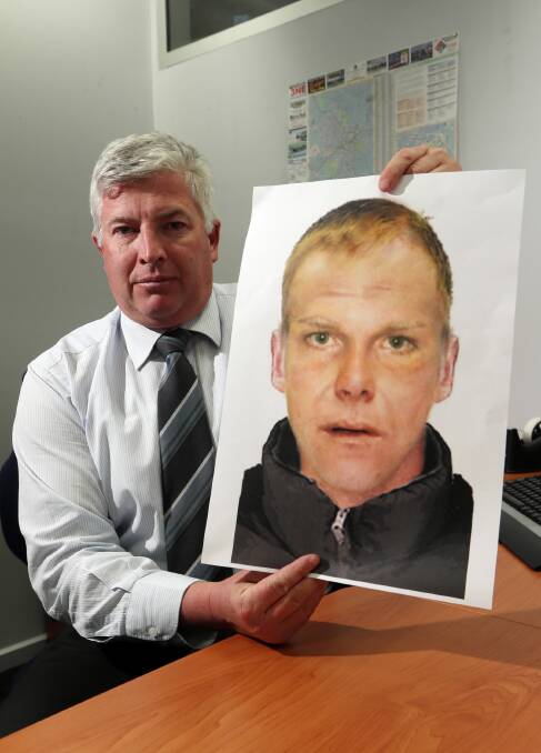 Sen-Constable Paul Campbell holds a computer-generated image of the man wanted. Picture: JOHN RUSSELL