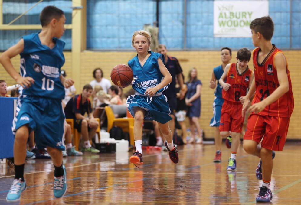 Ben Crombie, 12, takes the ball along the outside of the court for the Victorian Goldminers.