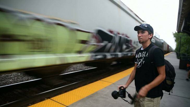 Stephen Schmidt, 18, a young train enthusiast, watches a passing train. Photo: Chicago Tribune