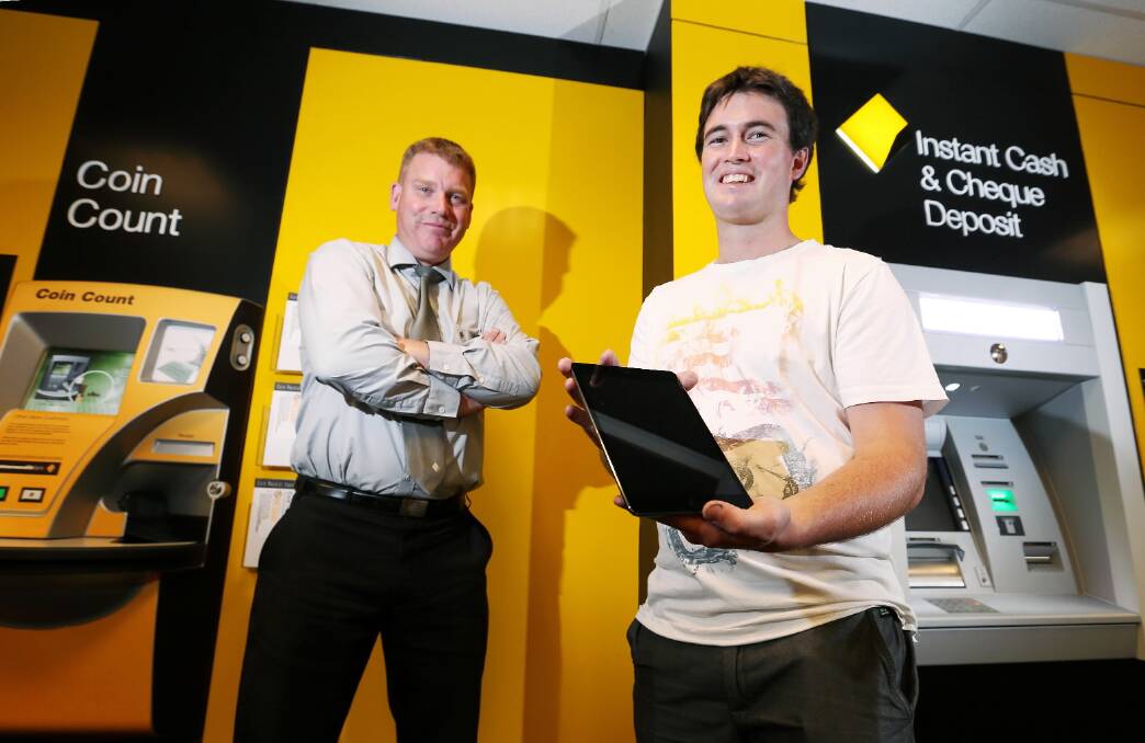 Commonwealth Bank Wodonga manager Paul Barton with winner of an iPad mini, Jake Creamer, inside the branch. Picture: JOHN RUSSELL