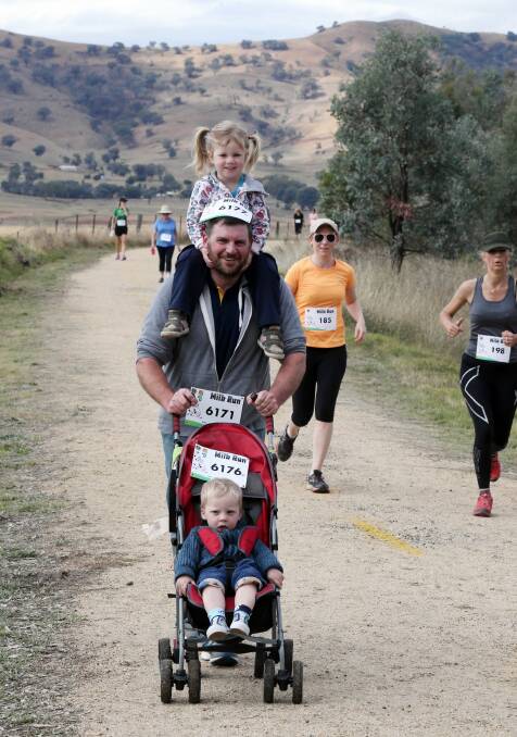 Dave Goodwin and his children, Isabel, 4, and Josef, 2, from Huon, finish the six-kilometre walk at yesterday’s Milk Run event. Picture: PETER MERKESTEYN