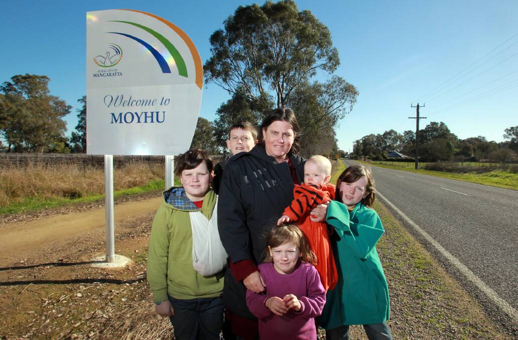 Happy Moyhu residents Justin Ritchens-Hall, 10, Jarrod Ritchens-Hall, 12, Kylie Ritchens-Hall, Jane Ritchens-Hall, 5, Jewel Ritchens-Hall, 7 months, and Jena Ritchens-Hall, 8, near the town sign. Picture: KYLIE Esler