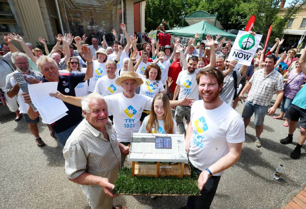 LEFT: Les Keeble, Grace Rutherford, 12, and Matthew Grogan holding a model of a renewable house at the centre on Saturday. Picture: JOHN RUSSELL