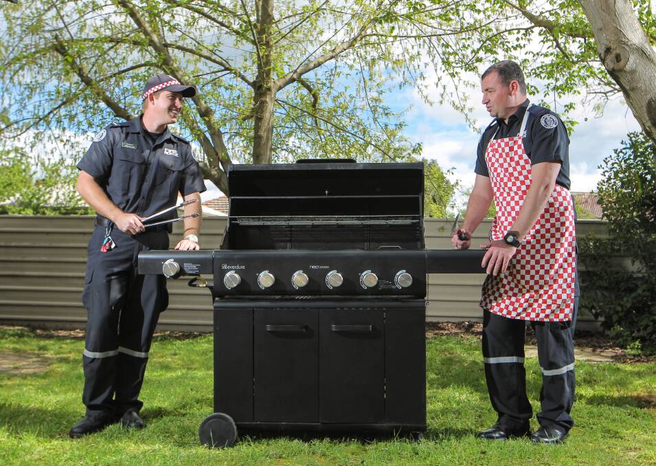 Firefighters Greg Williams and Ross Iudica have ensured their gas barbecue is in tip-top condition for their grand final barbecue and also for the rest of the summer. Picture: DYLAN ROBINSON