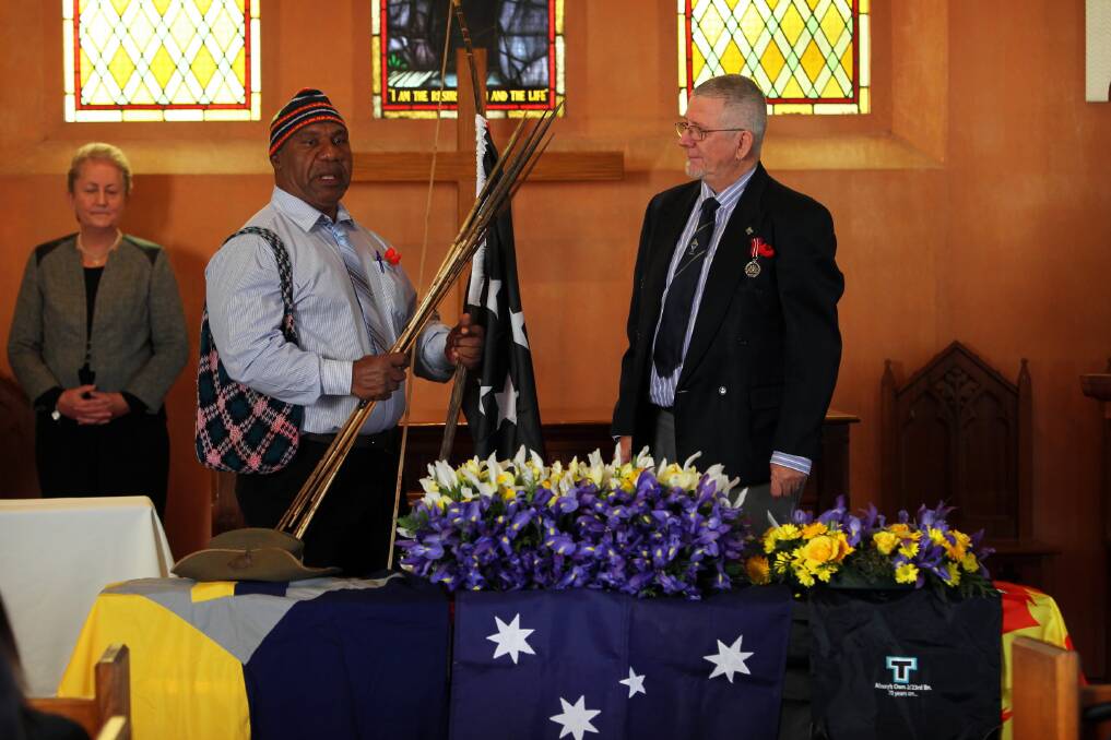 Pastor Magi Goro presents Kenn Iskov with a traditional bow and arrows, echoing Mr Iskov’s war service on the Kokoda Track 72 years ago.