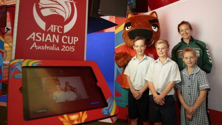 AFC Asian Cup mascot Nutmeg, Canberra United player Grace Gill, front from left, Trinity Christian School year 7 student Ben Carling, year 6 student Tim Noack and year 4 student Mali Vanderstoep at the Join the Team photo booth at the AFC Asian Cup Football Fan Park at Garema Place. Photo: Jeffrey Chan