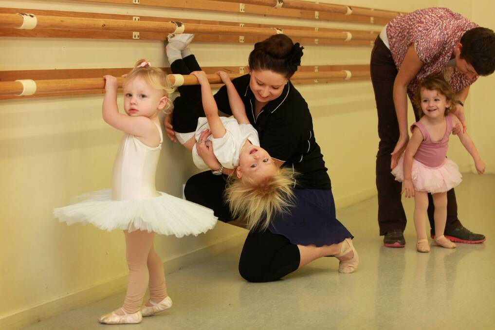 Teacher Keira Gush supports Maurice Brown, 2, as he makes acrobatic use of the barre. Picture: MATTHEW SMITHWICK