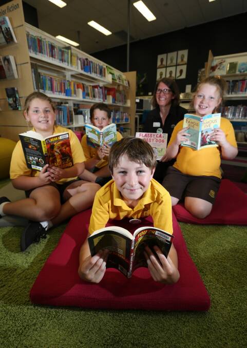 It didn’t take much for librarian April Wood to get Lavington Public School students Paris Barnes, Archie Arnold, Aric Reimers and Ava Milligan into the swing of reading. Picture: MATTHEW SMITHWICK