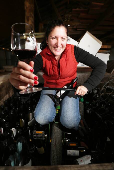 Meghan Gehrig sits in an old wine vat filled with bottles of wine that will be part of a guessing game during Winery Walkabout. Picture: JOHN RUSSELL
