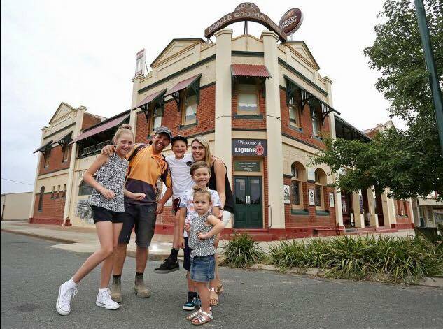 SAD FAREWELL: Josh and Tania Corrigan with their four children. The family is selling the Doodle Cooma Arms to spend more time together.