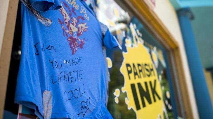 SAD REMINDER: A shirt with a message dedicated to shooting victim Jillian Johnson hangs on the storefront window of Johnson's store Parish Ink in downtown Lafayette. Photo: THE DAILY ADVERTISERS