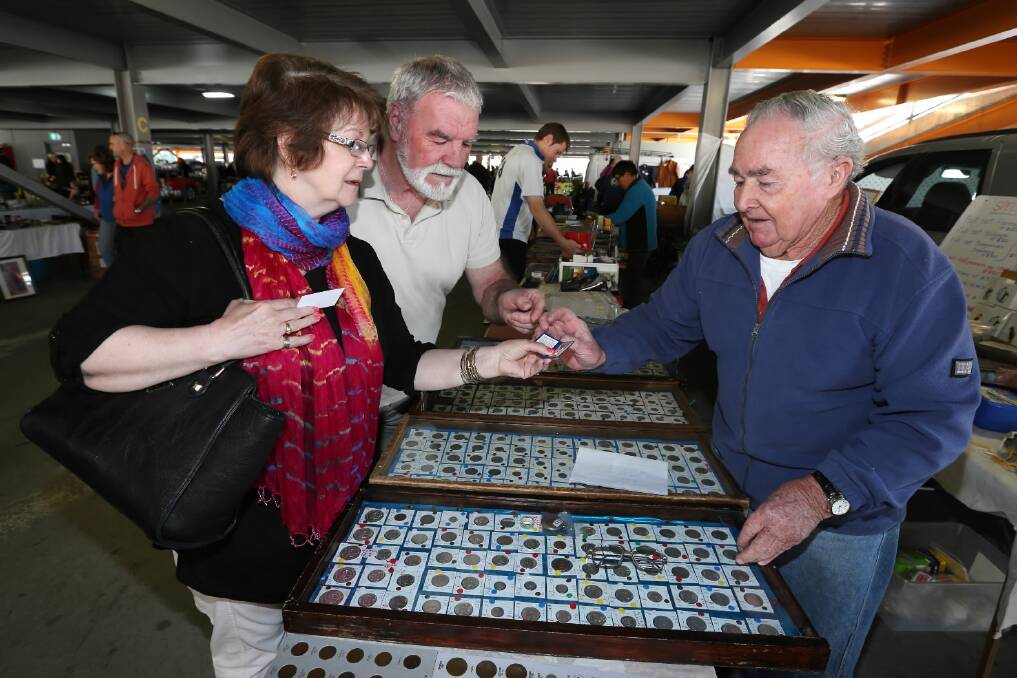 MONEY, MONEY, MONEY: Albury bargain hunters Janet and Harry Brown inspect some vintage coins on George White's stall at the Albury-Wodonga Community Market, held every Sunday at Albury's Wilson Street carpark. Picture: MATTHEW SMITHWICK