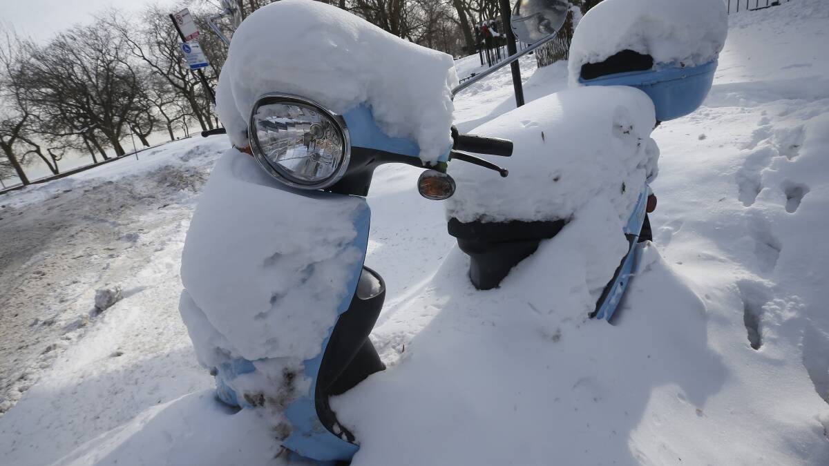 A snow covered scooter is seen in Chicago, Illinois, January 8, 2014. Photo: REUTERS/Jim Young.