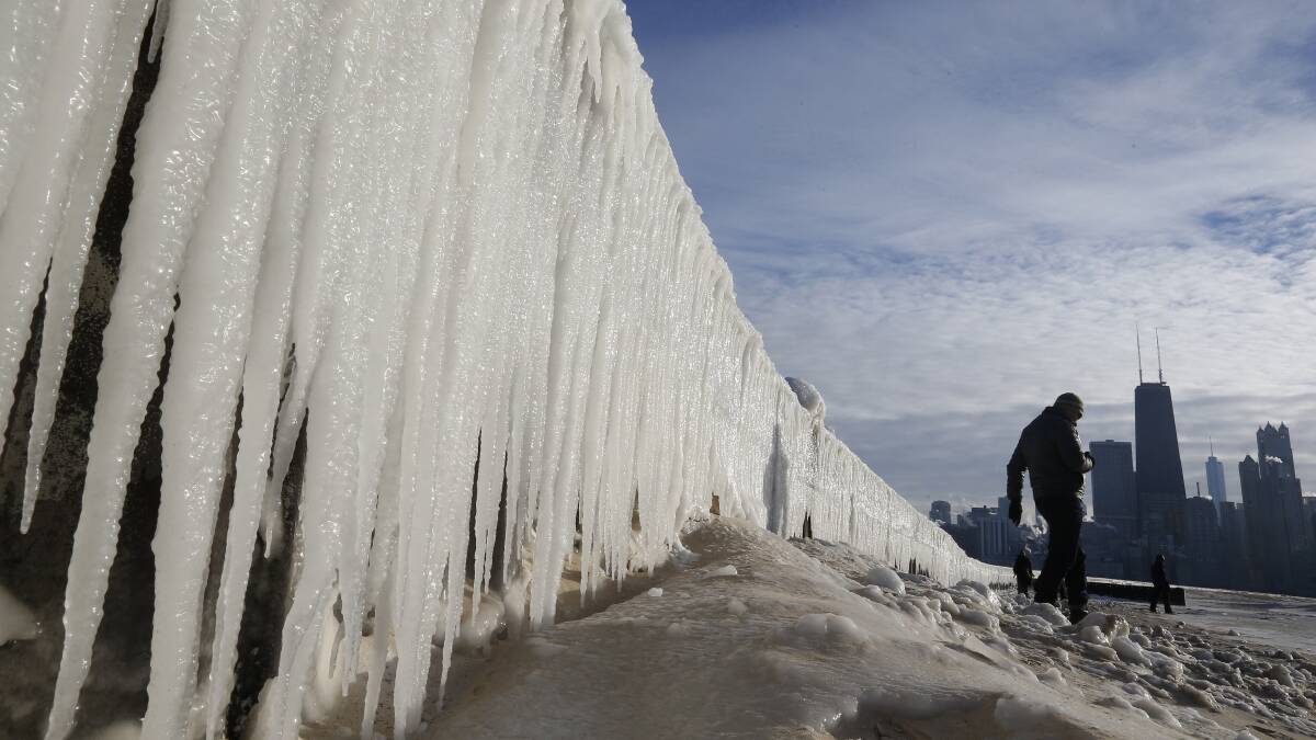 A man walks beside a frozen wall on a beach in Chicago, Illinois, January 7, 2014. Photo: REUTERS/Jim Young.