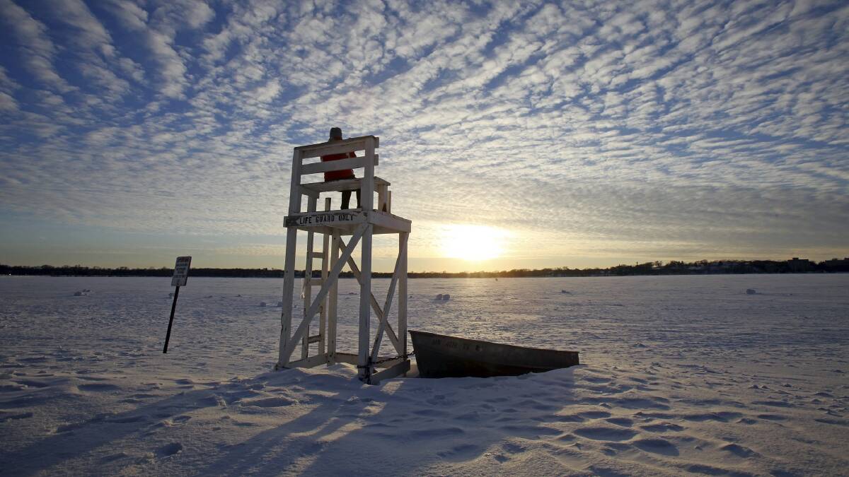 Jennifer Berry watches the sunset from a lifeguard chair at a beach on Lake Calhoun in Minneapolis, January 7, 2014. Photo: REUTERS/Eric Miller.