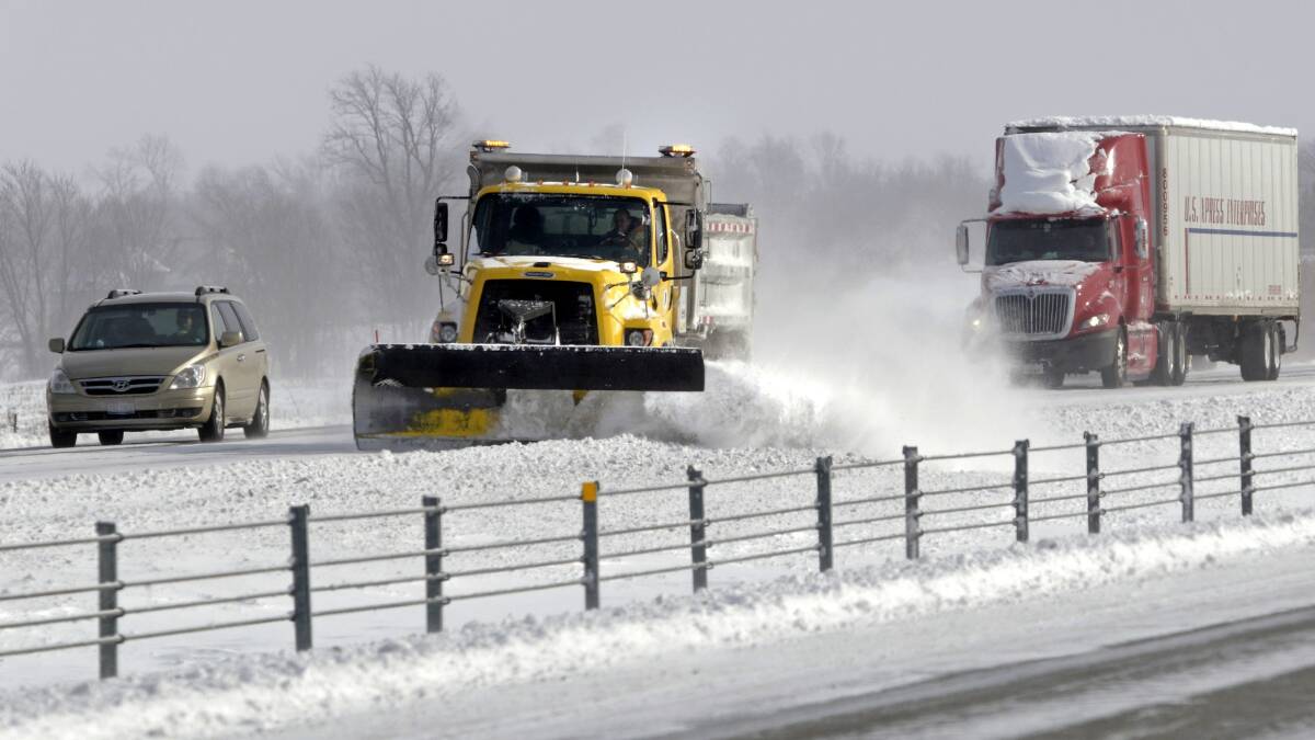 A snow plow clears the road on Interstate 65 north of Indianapolis, Indiana January 6, 2014. Photo: REUTERS/Nate Chute.