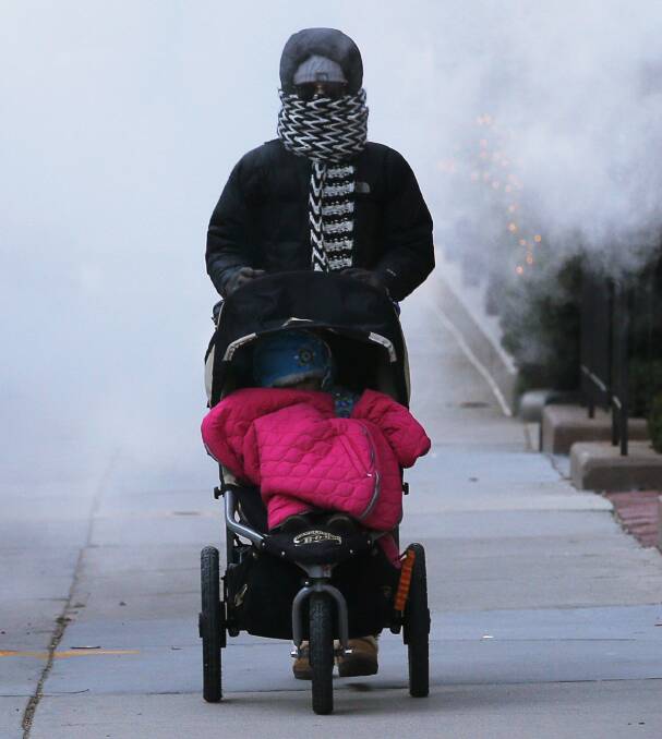 A woman pushes a baby stroller through a cloud of steam from a construction site in Boston, Massachusetts January 7, 2014. Photo: REUTERS/Brian Snyder.