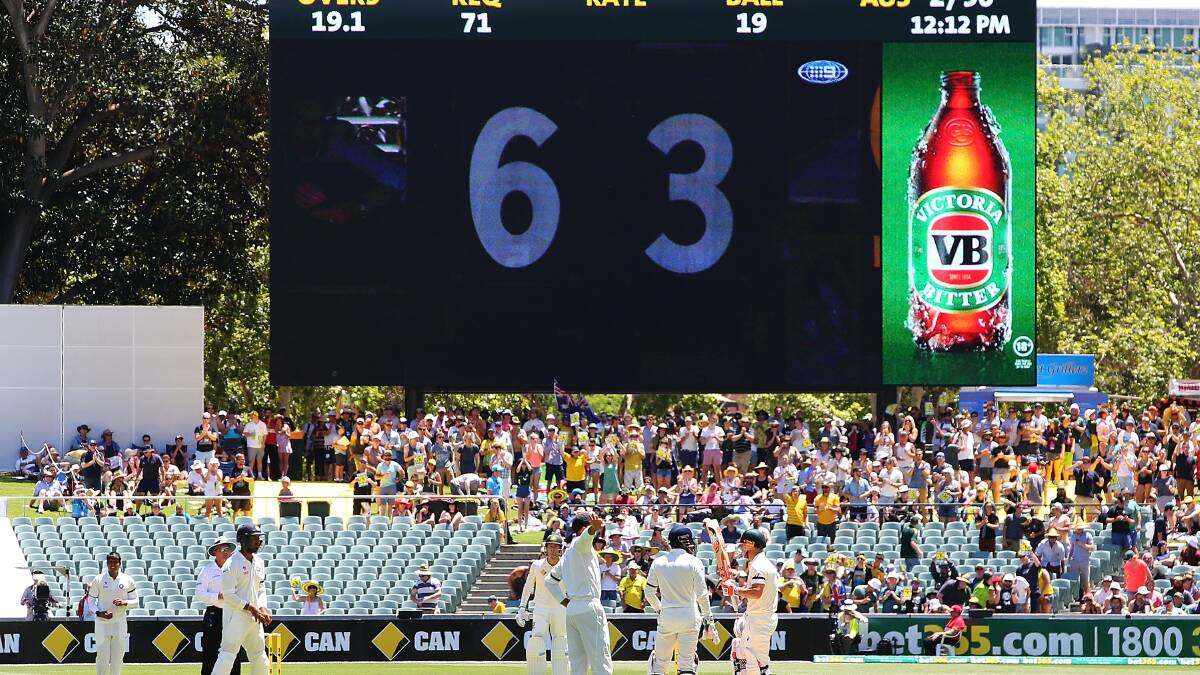 David Warner of Australia pays tribute to Phillip Hughes after reaching 63 during day one of the First Test match between Australia and India at Adelaide Oval. Photo: Getty Images.