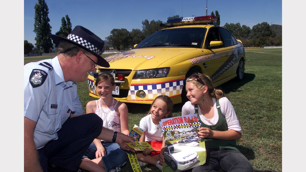 Police Blue light social day at McNamara Reserve Myrtleford. Snr Constable Barry Harris from Wangaratta Traffic Management Unit shows local girls L-R. Nicki Ives 12. Tazma Wyatt 7 and Alisha Woodall 12 his new police car. Picture: RAY HUNT