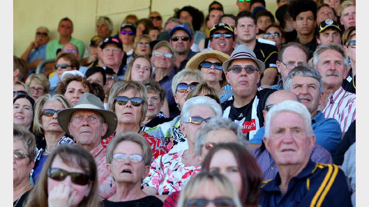 The crowd in the grandstand is fixated on the action at the Norm Minns Oval, Wangaratta