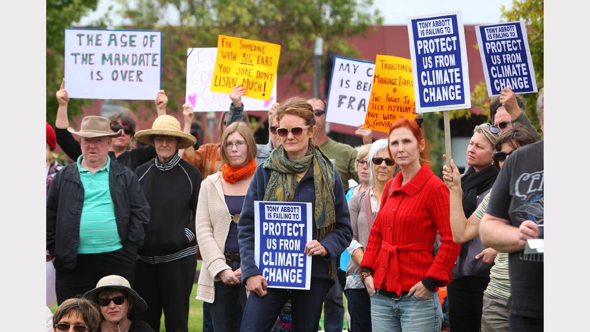 Protesters with placards attend the March in March protest objecting to the Abbott Government, held in Woodland Grove, Wodonga.