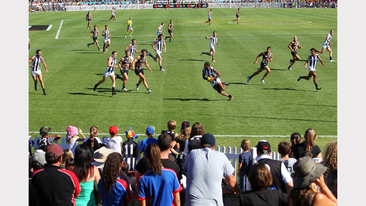 The crowd laps up the action as the Magpies' Heritier Lumumba takes the ball.